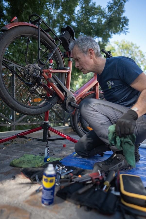 Patrick, réparateur Roulez Jeunesse, en train de nettoyer et lubrifier la chaîne d'un vélo