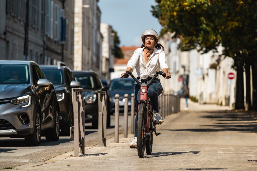 Une cycliste heureuse de pédaler après avoir profité du Bonus Répar Vélo