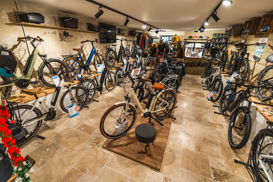 Cycliste confus face au choix de vélos, illustrant la complexité de l'achat d'un vélo