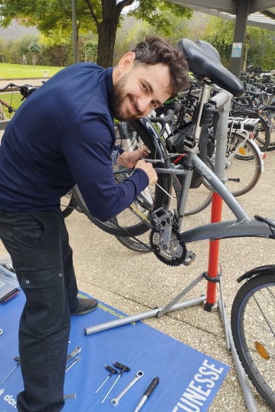 Un réparateur Roulez Jeunesse organise un atelier réparation vélo en entreprise