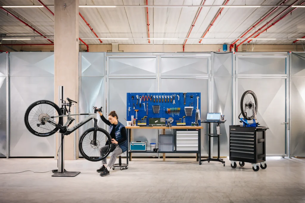 Atelier de reconditionnement de vélos électriques Upway avec des techniciens au travail