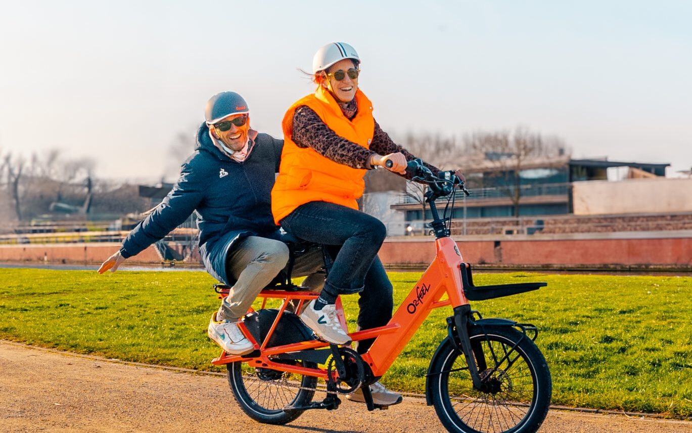 Vélo cargo shortail électrique O2feel Buzz gris avec porte-bagages arrière MIK HD et passager