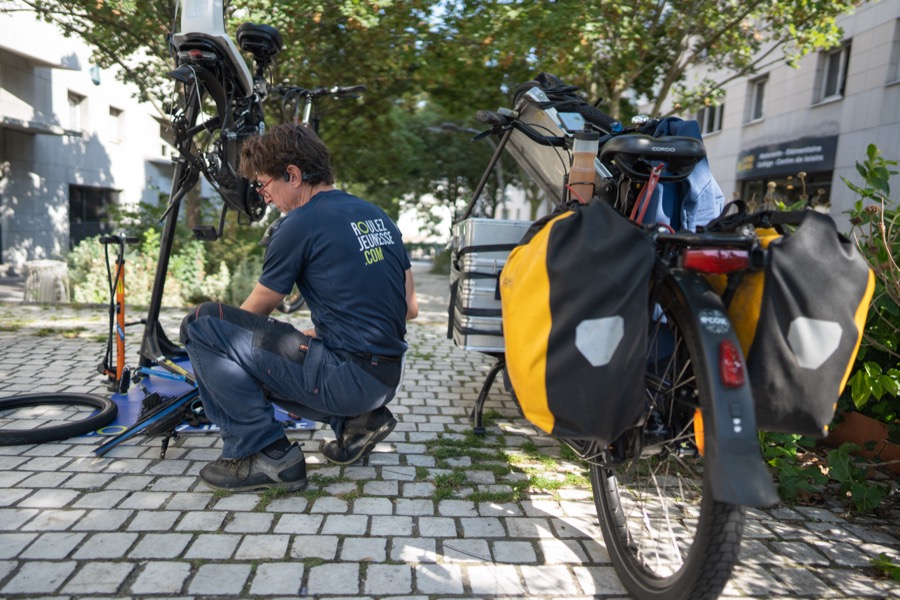réparateur vélo accroupi atelier mobile sacoches cargo urbain Bordeaux Roulez Jeunesse