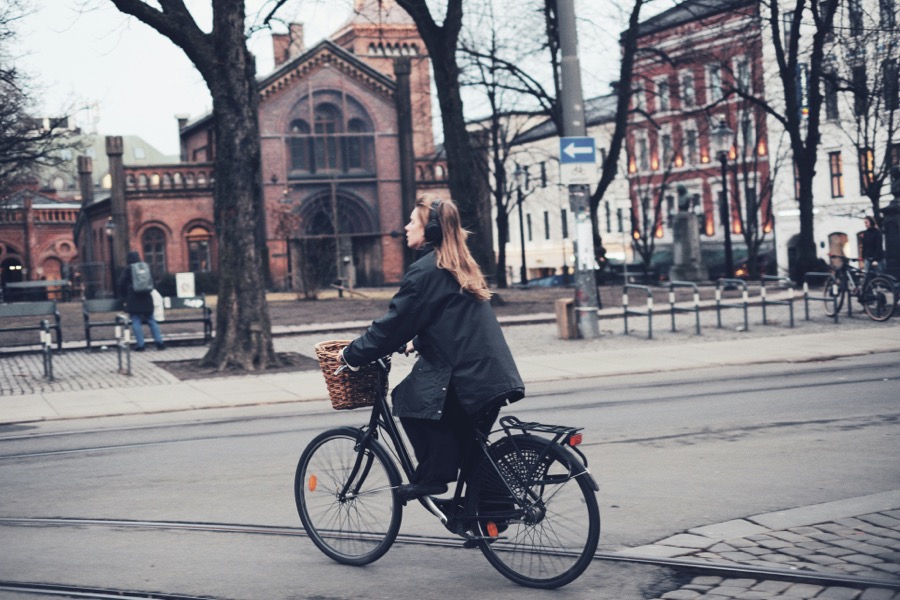 Cycliste urbaine roulant avec un casque audio sur les oreilles en ville