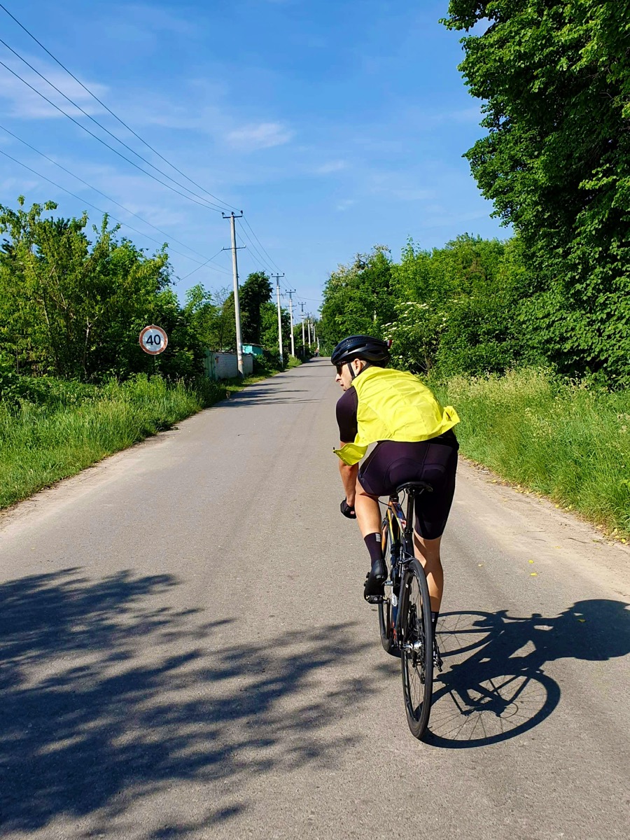 Cycliste sur une route de campagne hors agglomération portant une veste jaune haute visibilité