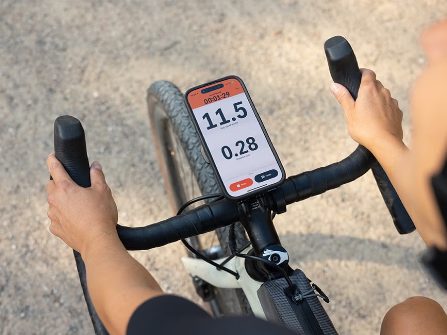 Téléphone fixé sur un support de cintre Quad Lock affichant un GPS à vélo, solution conforme au Code de la route