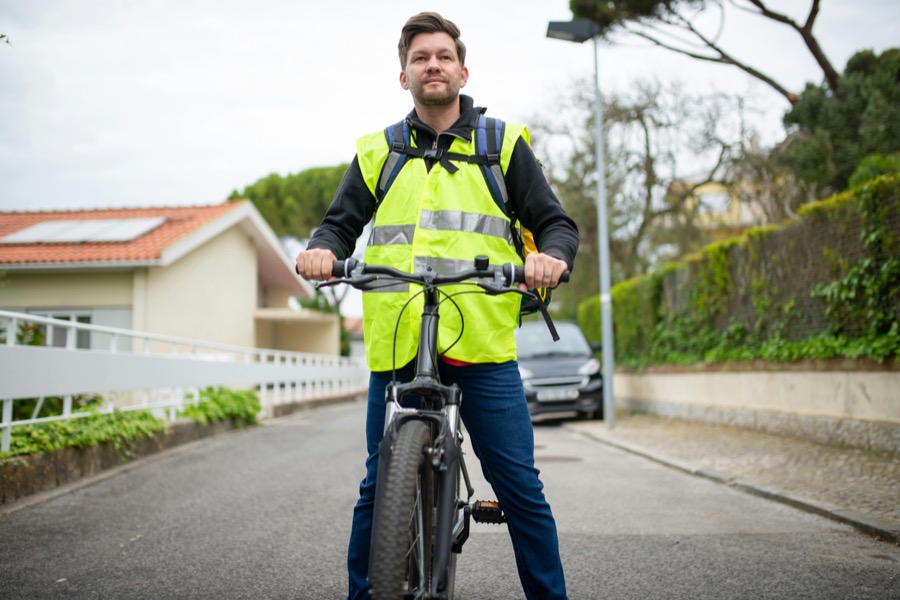 Cycliste portant un gilet de haute visibilité jaune homologué CE pour rouler à vélo