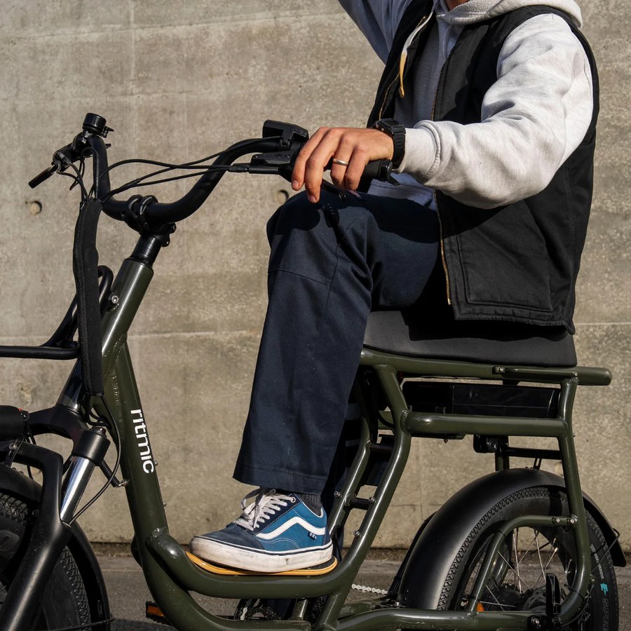 Cycliste installé sur le Ritmic Yuvy 3 Vert Oxford, pied sur le repose-pied passager rabattable
