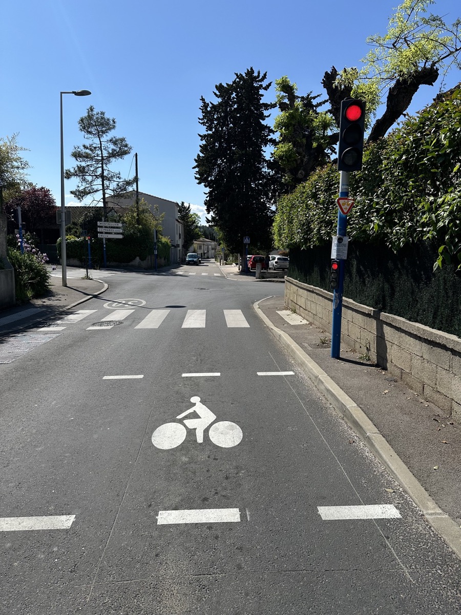 Sas vélo matérialisé devant un feu rouge, avec pictogramme vélo et ligne d'arrêt avancée