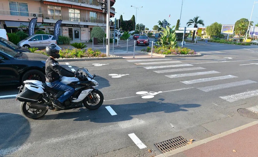 Moto à l'arrêt près d'un sas vélo à un carrefour