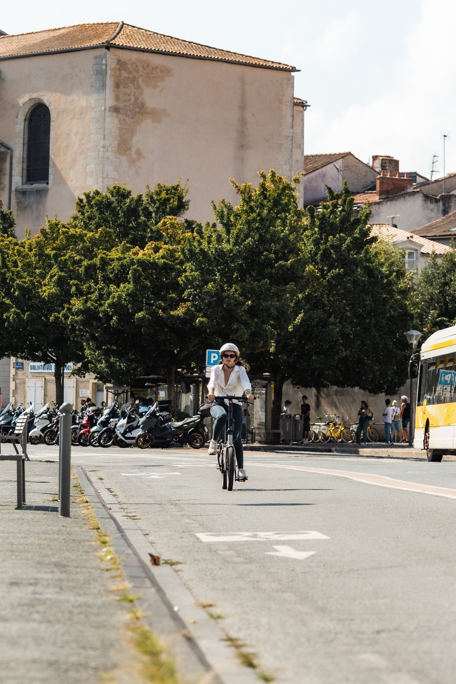 Cycliste casquée en ville sur piste cyclable, vélotaf par forte chaleur