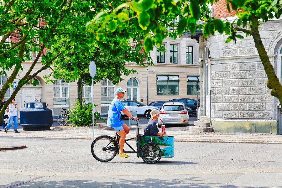 Vélo triporteur électrique à trois roues avec caisse avant en milieu urbain