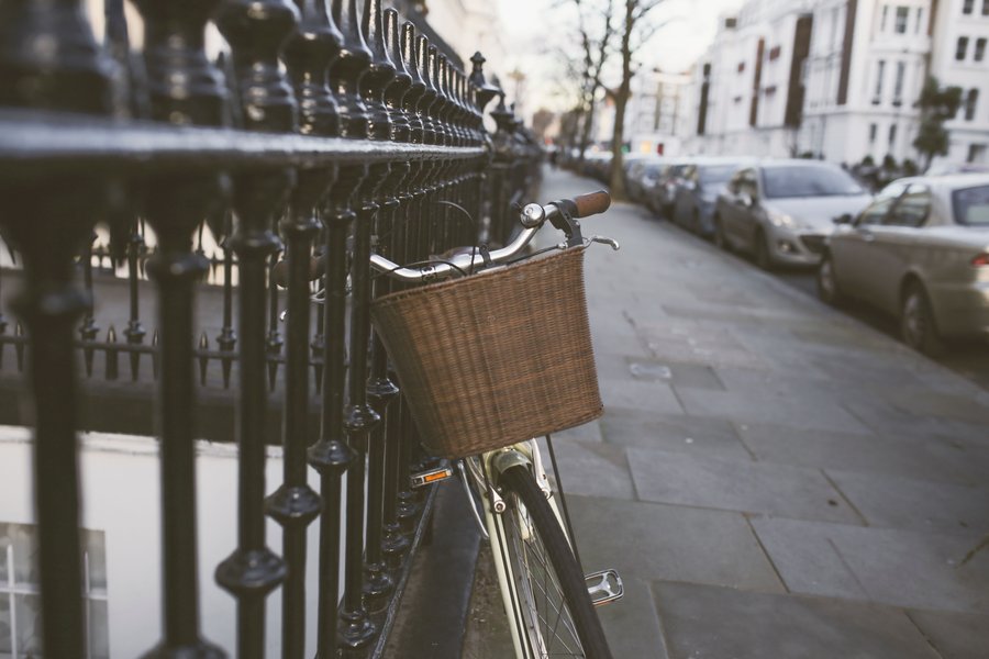 Vélo de ville garé avec un panier vélo en osier sur le guidon