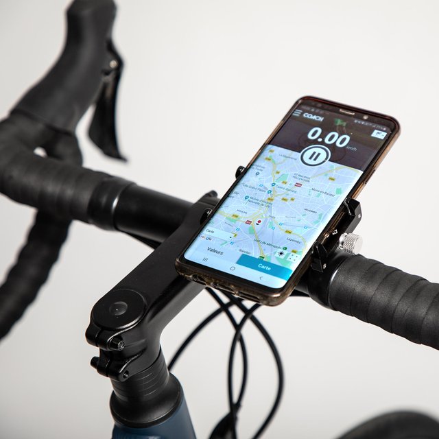 Support téléphone vélo à pince universelle Decathlon tenant un smartphone en navigation sur un cintre de vélo de route