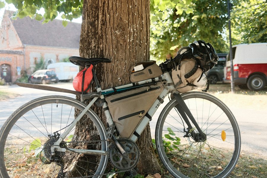 Vélo de voyage équipé de sacoches vélo étanches posé contre un arbre