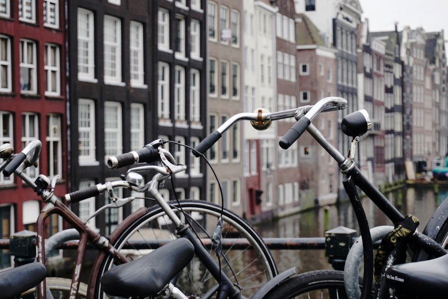 Guidons relevés de vélos hollandais stationnés le long d'un canal à Amsterdam
