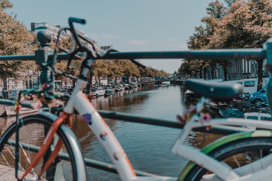 Vélo hollandais stationné le long d'un canal, garde-boue et carter de chaîne visibles