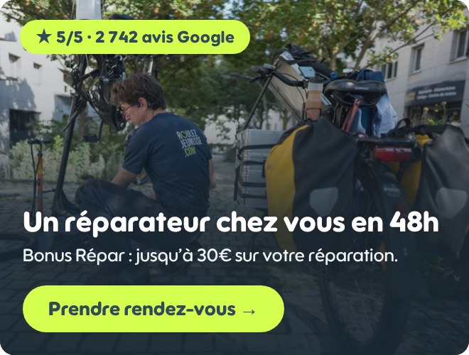 Un réparateur du réseau Roulez Jeunesse intervient sur un vélo chargé de sacoches : réparation à domicile en 48h, Bonus Répar jusqu’à 30€